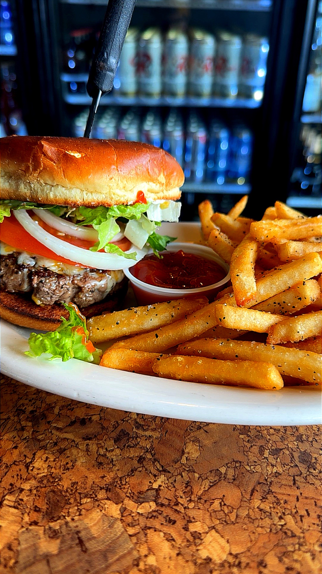 The B9 Burger topped with feta, lettuce, tomato, and onion, served with fries